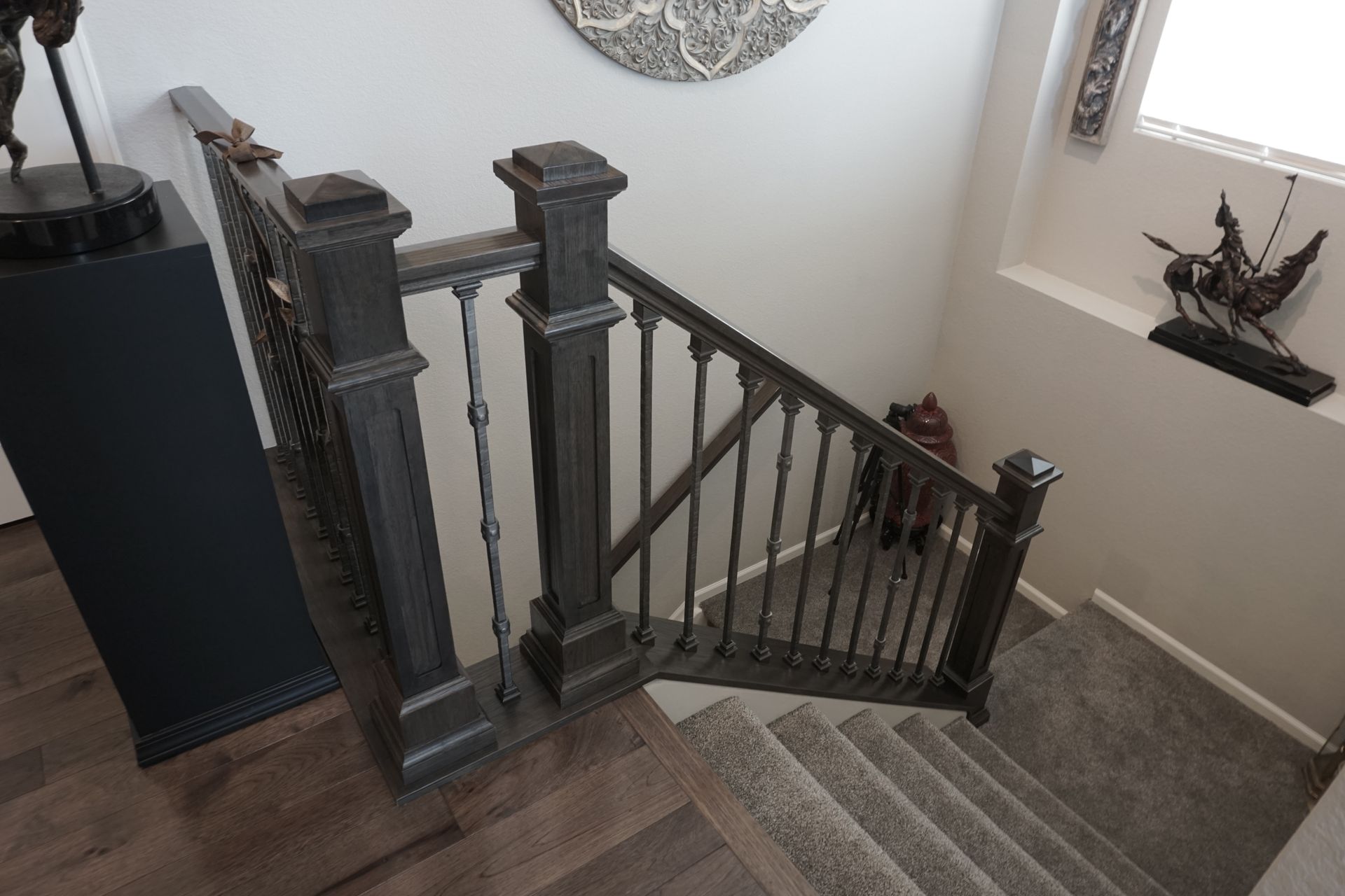 Staircase with dark gray railing and carpeted steps, leading downwards.