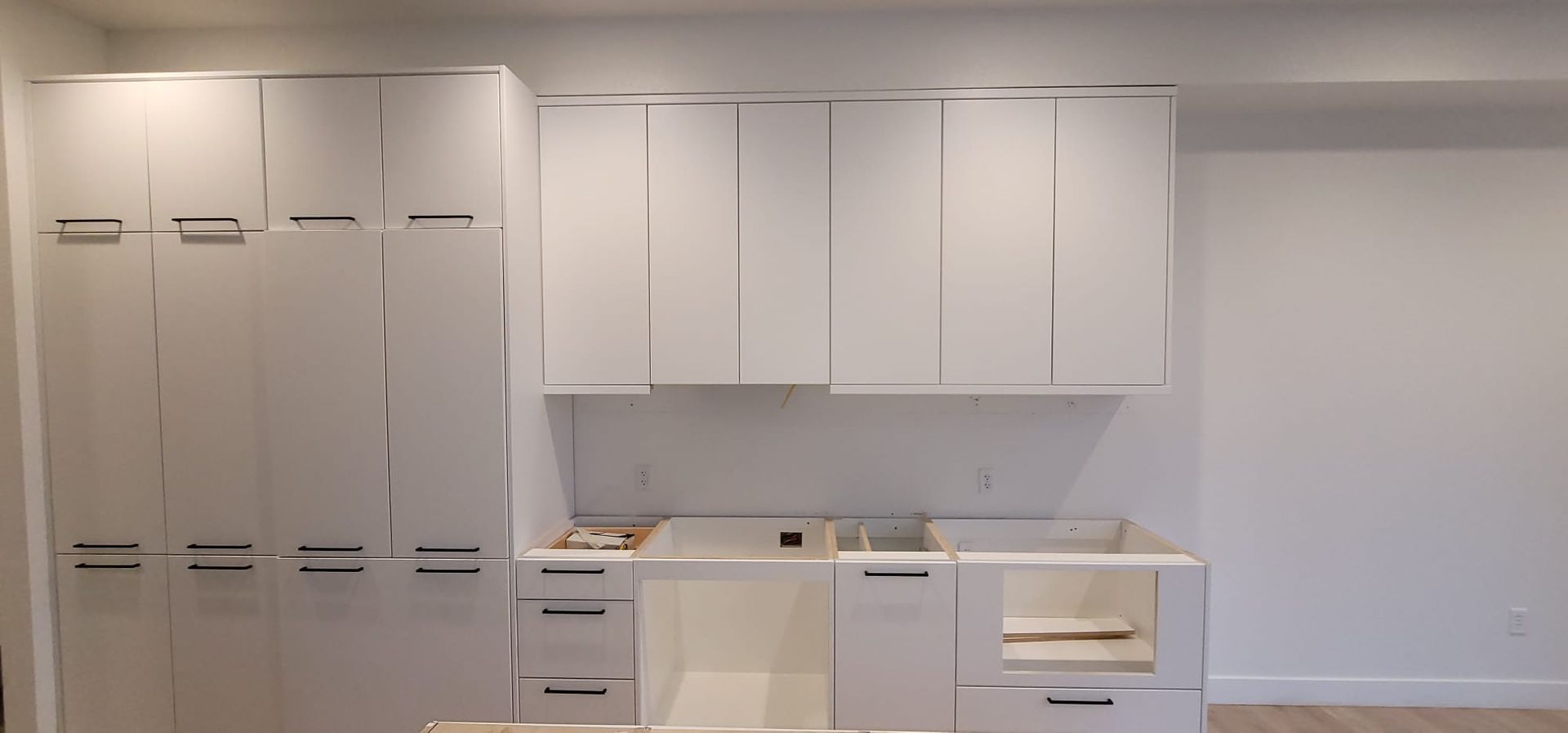 White kitchen cabinets and countertops being installed.