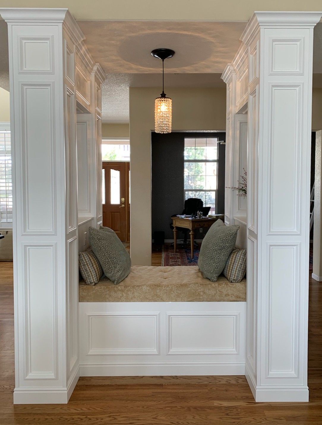 A living room with hardwood floors and white columns.