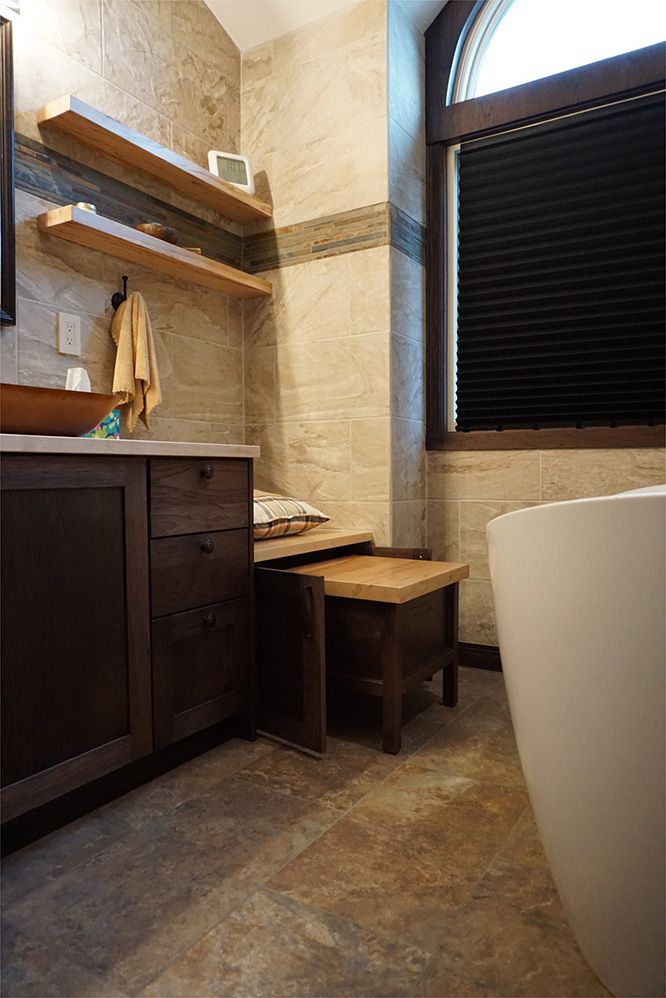 Bathroom with dark wood vanity, floating shelves, and a freestanding tub.