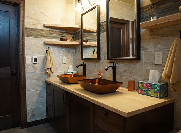 Bathroom with brown wood vanity, vessel sinks, shelves, and a large mirror.