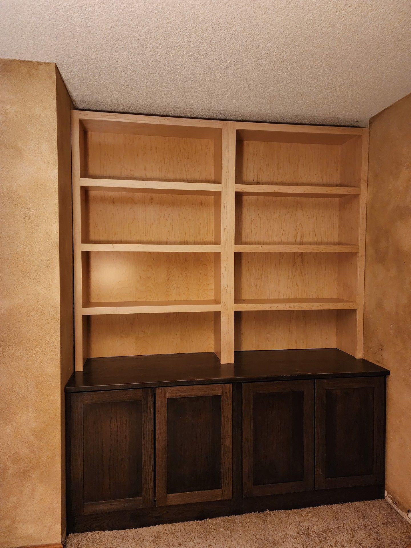 Wooden bookshelf unit; upper section has open shelves, lower section with dark brown doors.