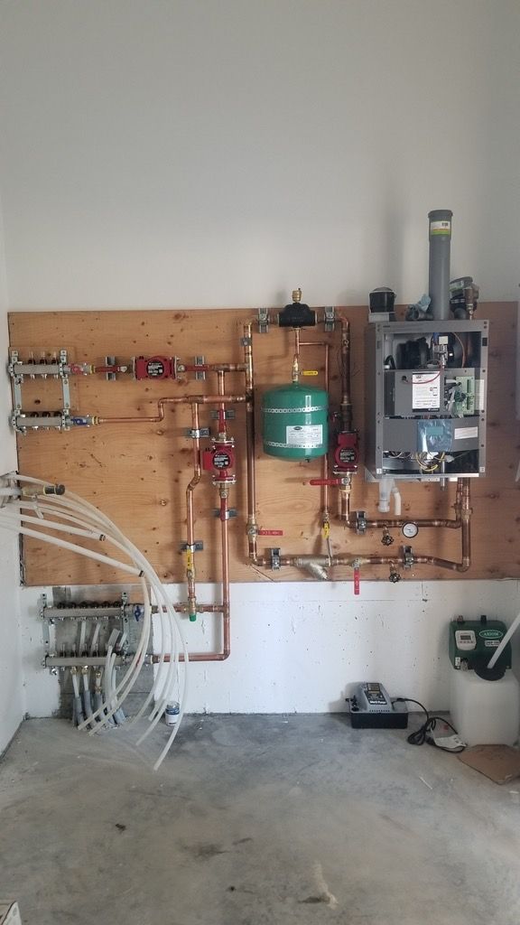 A room with a lot of pipes hanging on the wall.