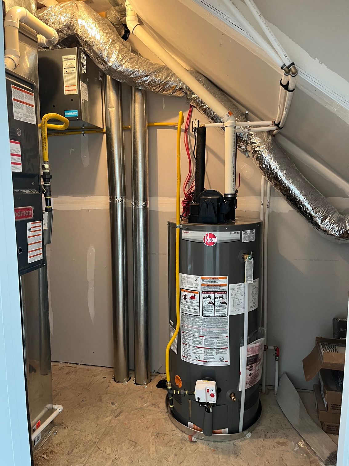 A water heater is sitting in a corner of a room.