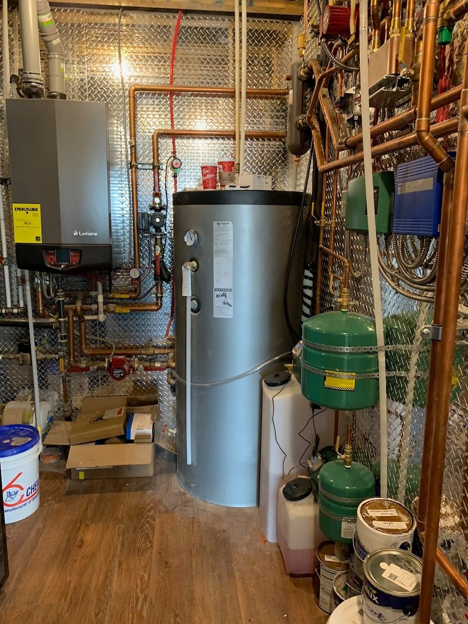 A room filled with lots of pipes and a water heater.