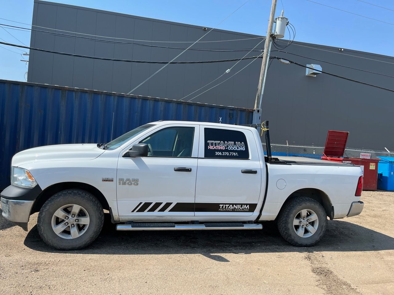A white truck is parked in front of a building.