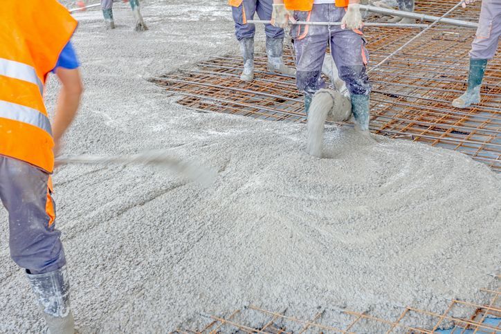 a group of construction workers are pouring concrete on a concrete floor