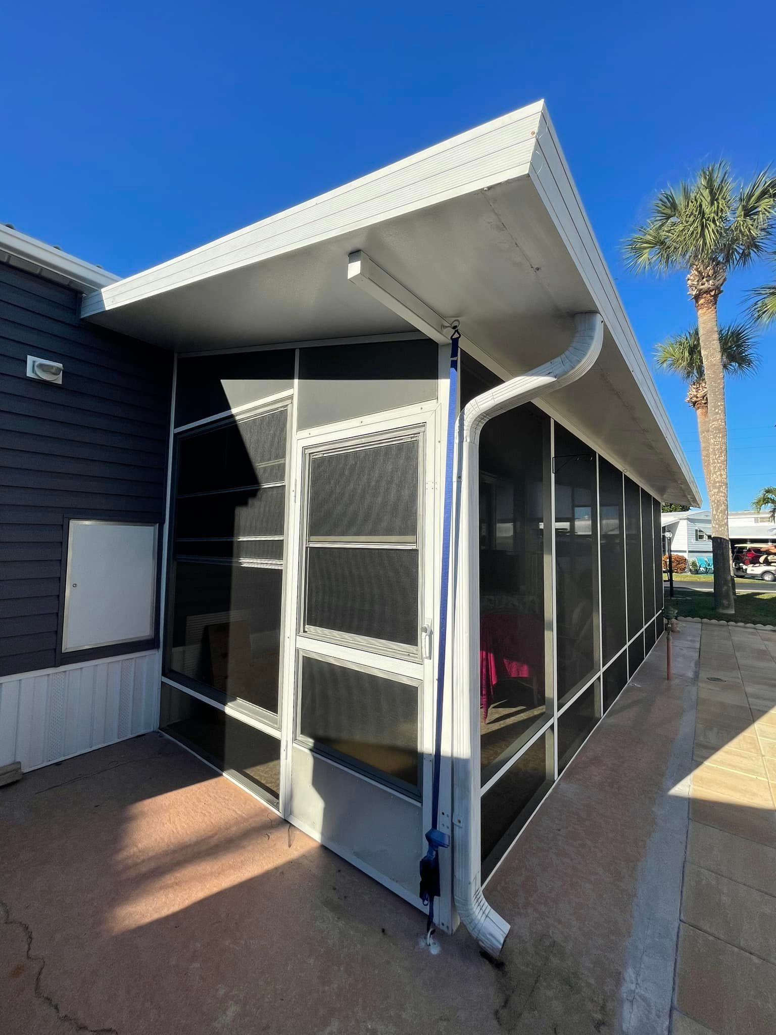 A full dumpster, surrounded by discarded furniture and appliances on a driveway.