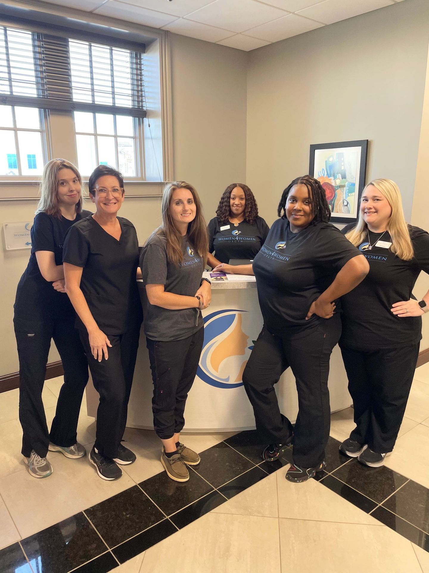 A group of women are posing for a picture in front of a counter.