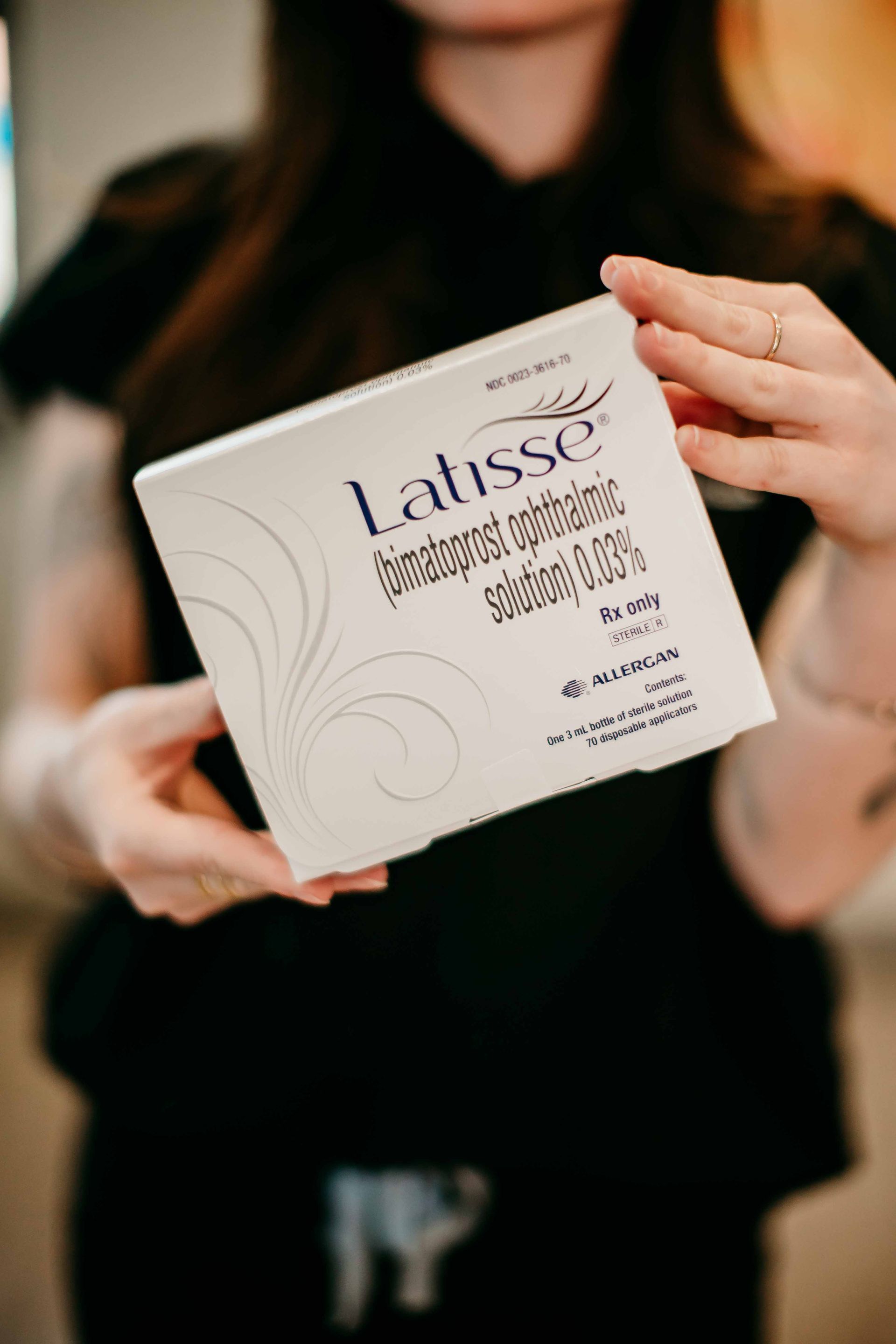 A woman is holding a box of latisse