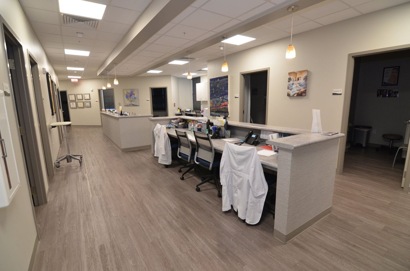 A long hallway with a reception desk in the middle of it.