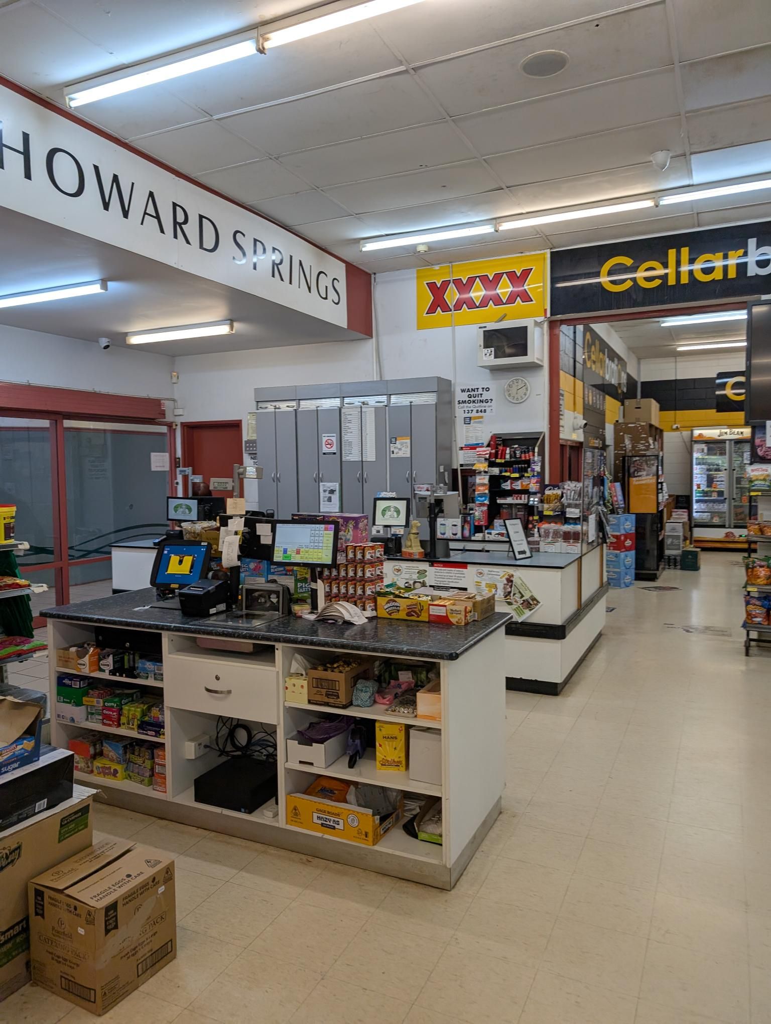 A Woman is Looking at Vegetables in a Grocery Store — Howard Springs Supermarket In Howard Springs, NT
