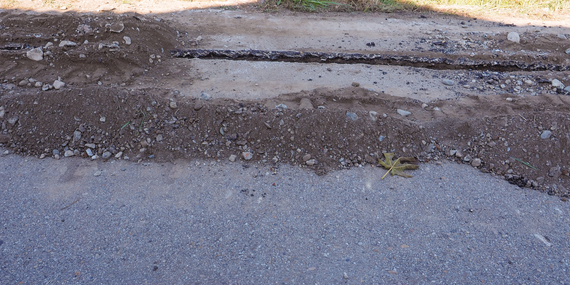 A puddle of water is sitting on the side of a road.