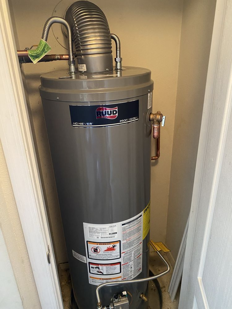 A tall, gray water heater with a vent pipe in a small closet.