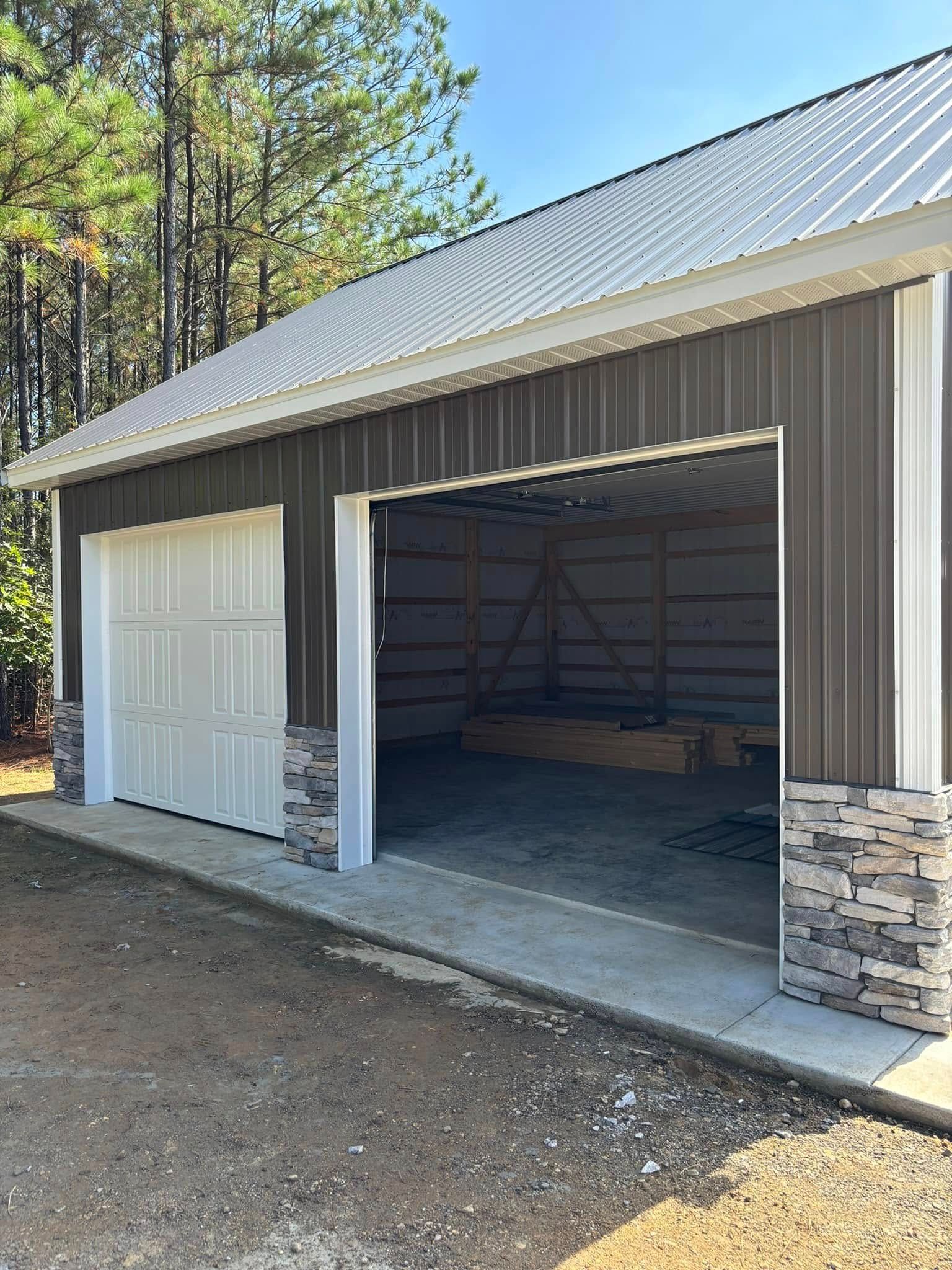A pole barn garage with two doors open and a white roof.