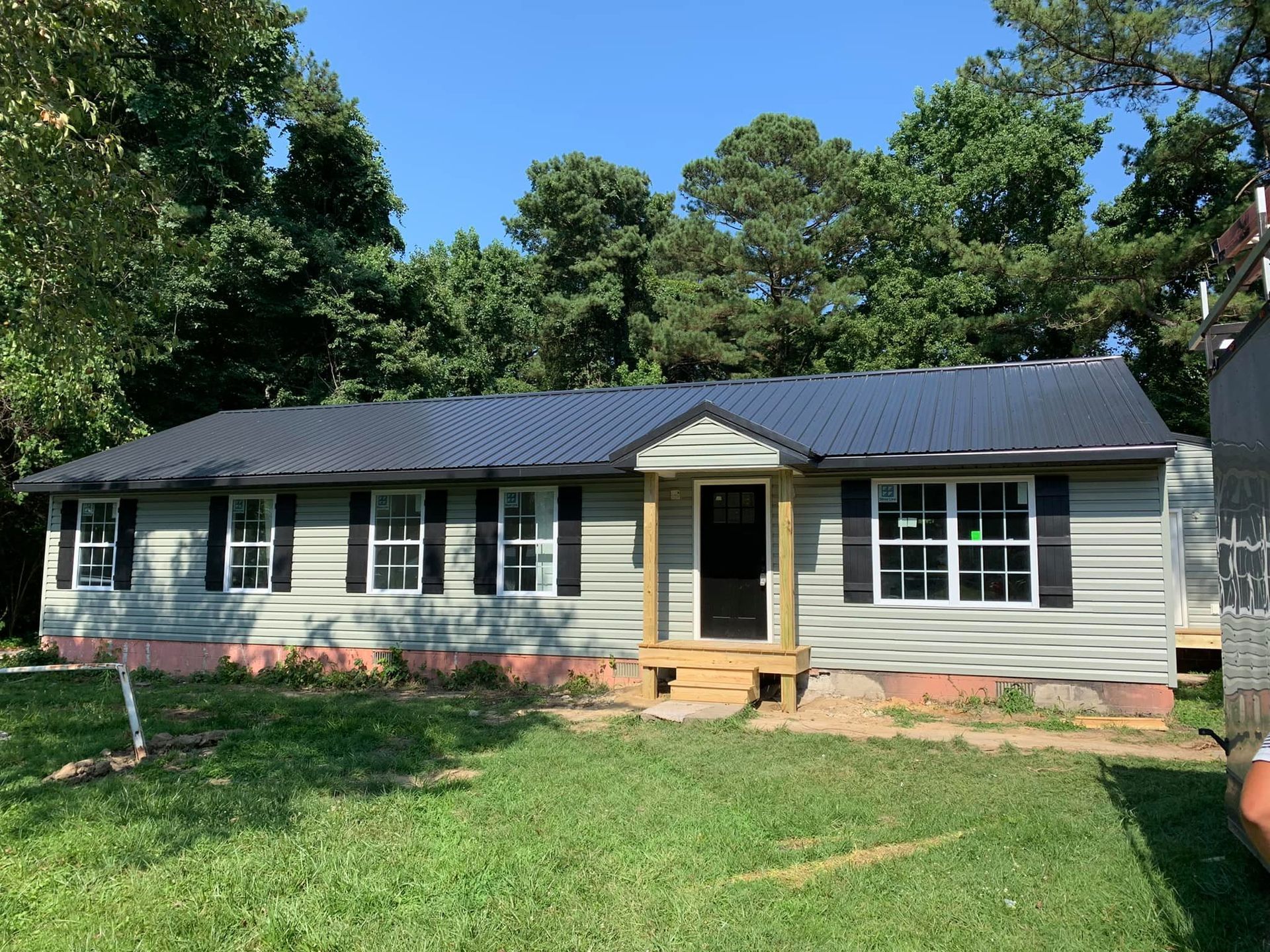 A rambler with a metal roof is sitting on top of a lush green field in Southern MD