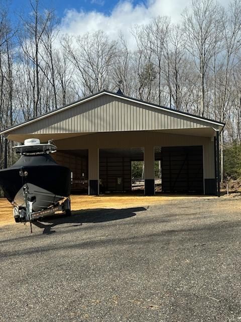 A boat is parked in front of a pole barn constructed garage.