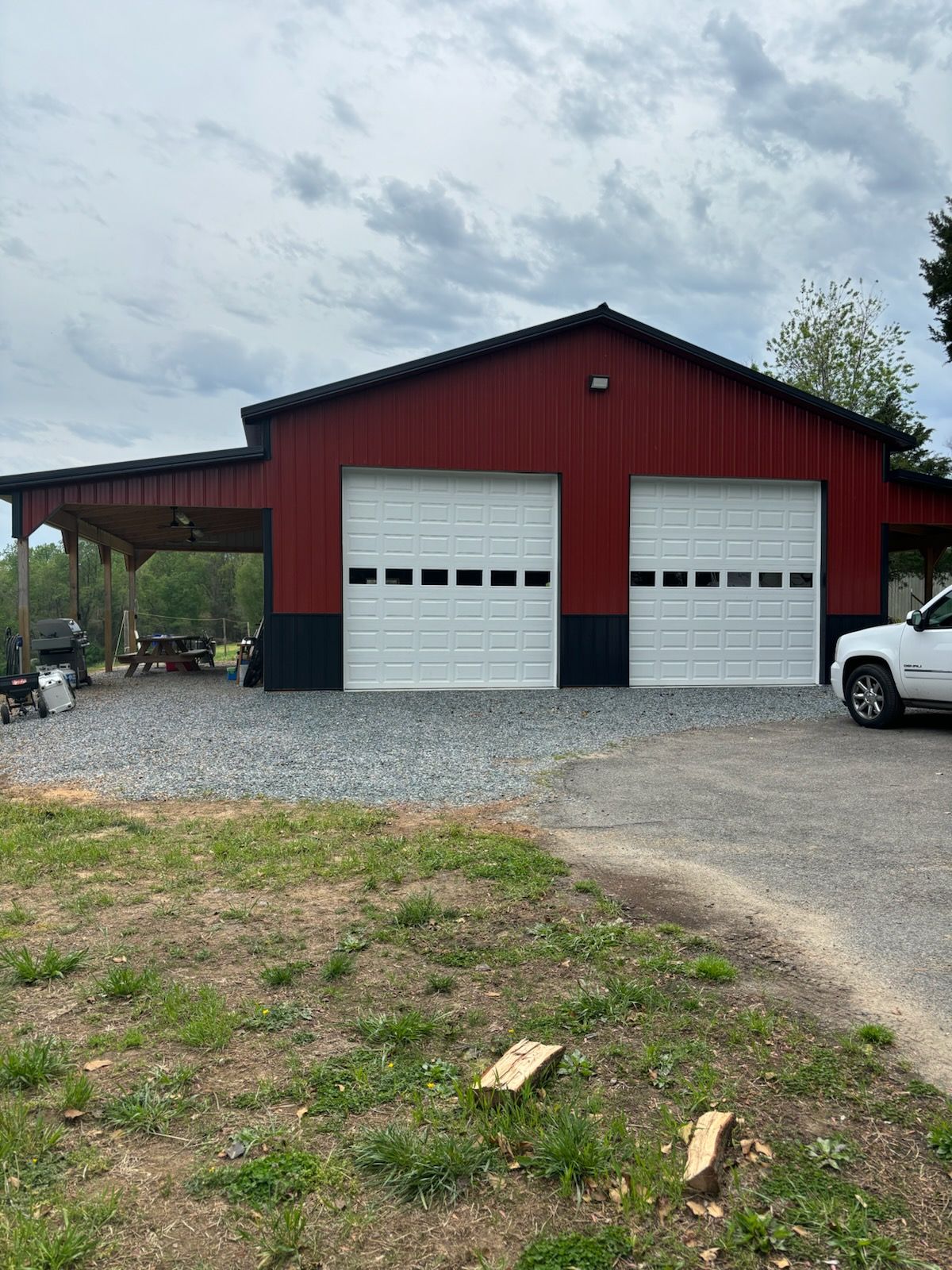 A red and white garage with a white truck parked in front of it.
