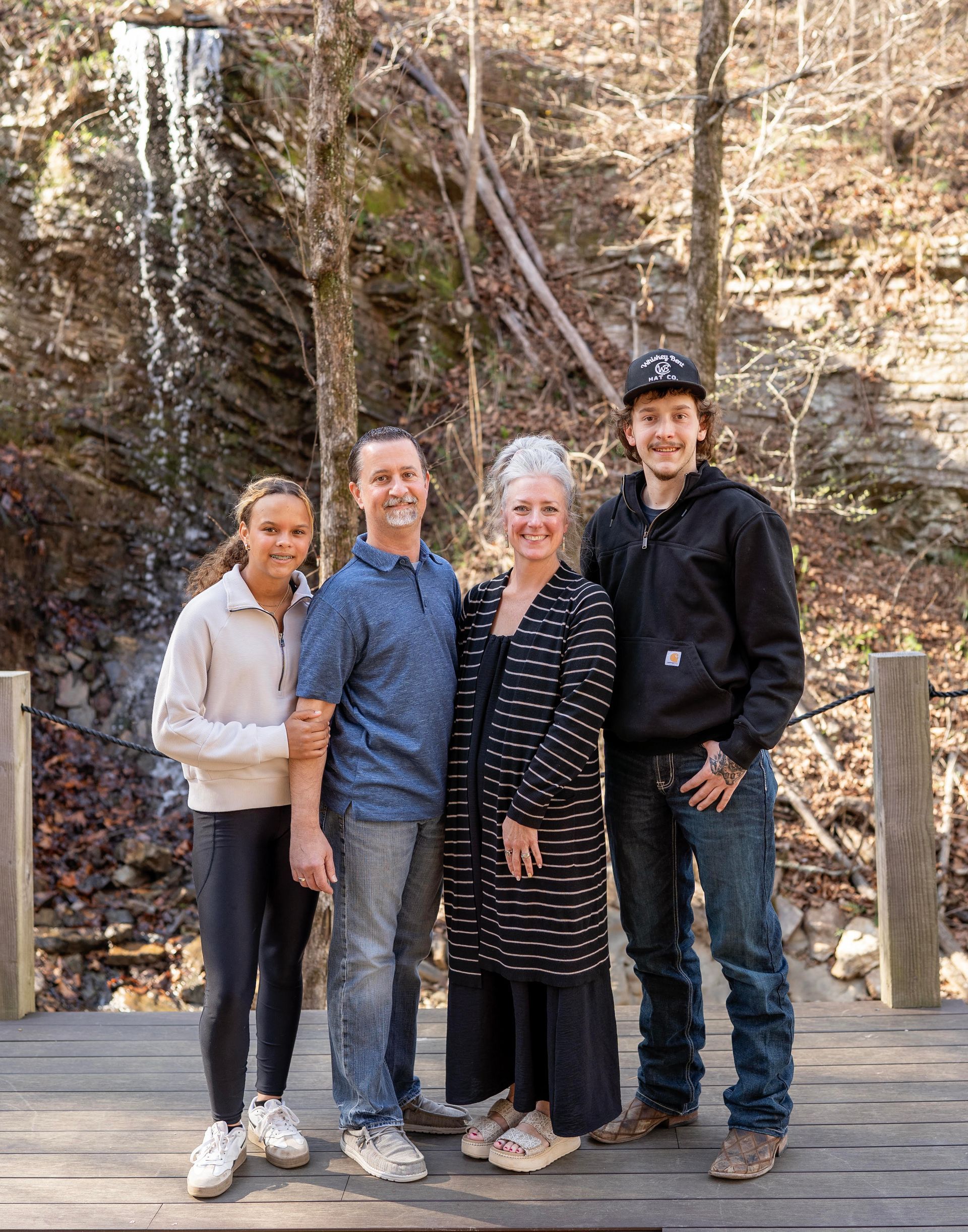 A family is posing for a picture on the beach.