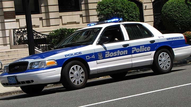 Boston Police car, blue and white, parked on a city street.