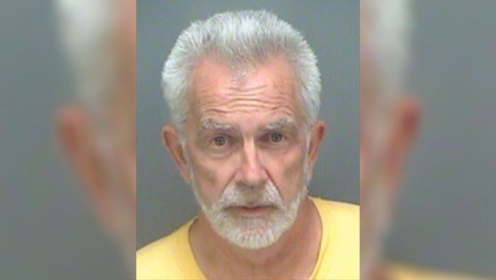 Man with gray hair and beard in a yellow shirt, mugshot-style photo.