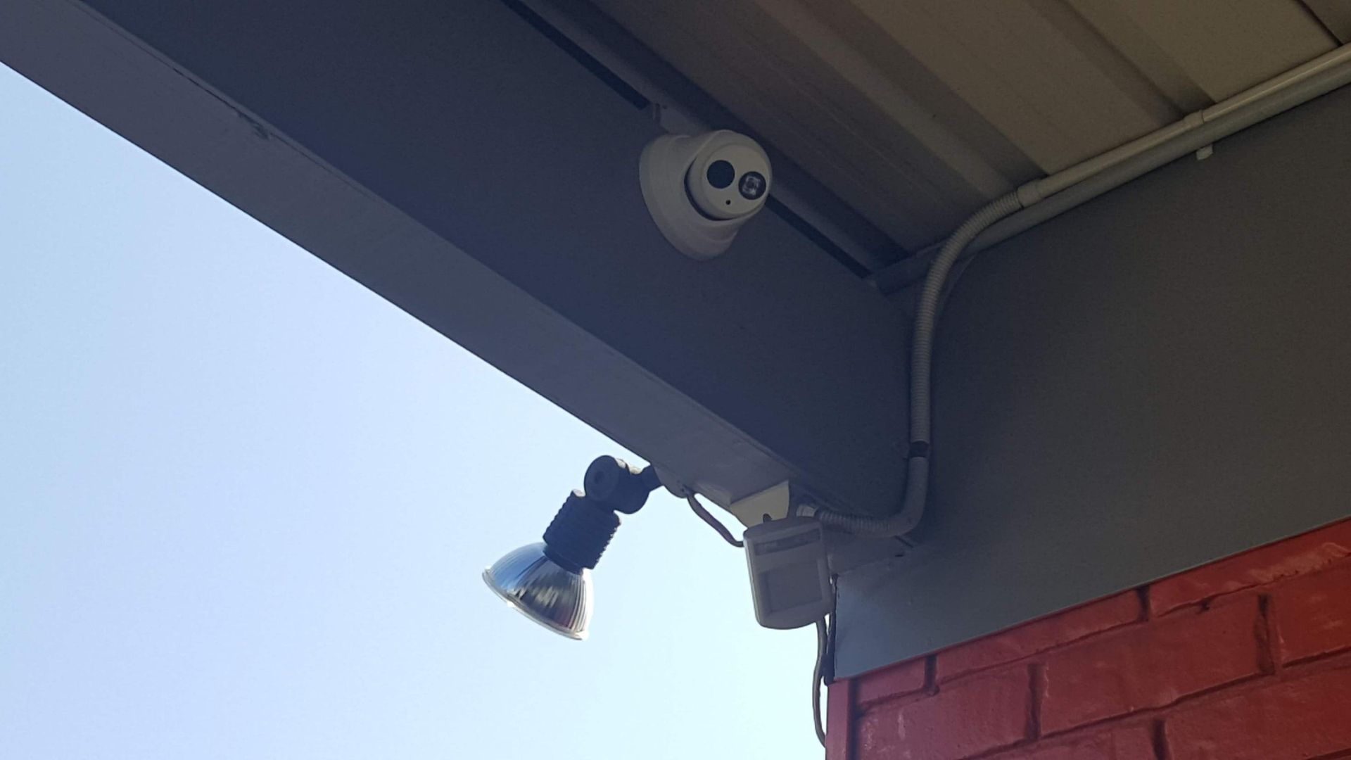 A Security Camera is Mounted on the Side of a Building — Direct Connect Services In Woombye, QLD