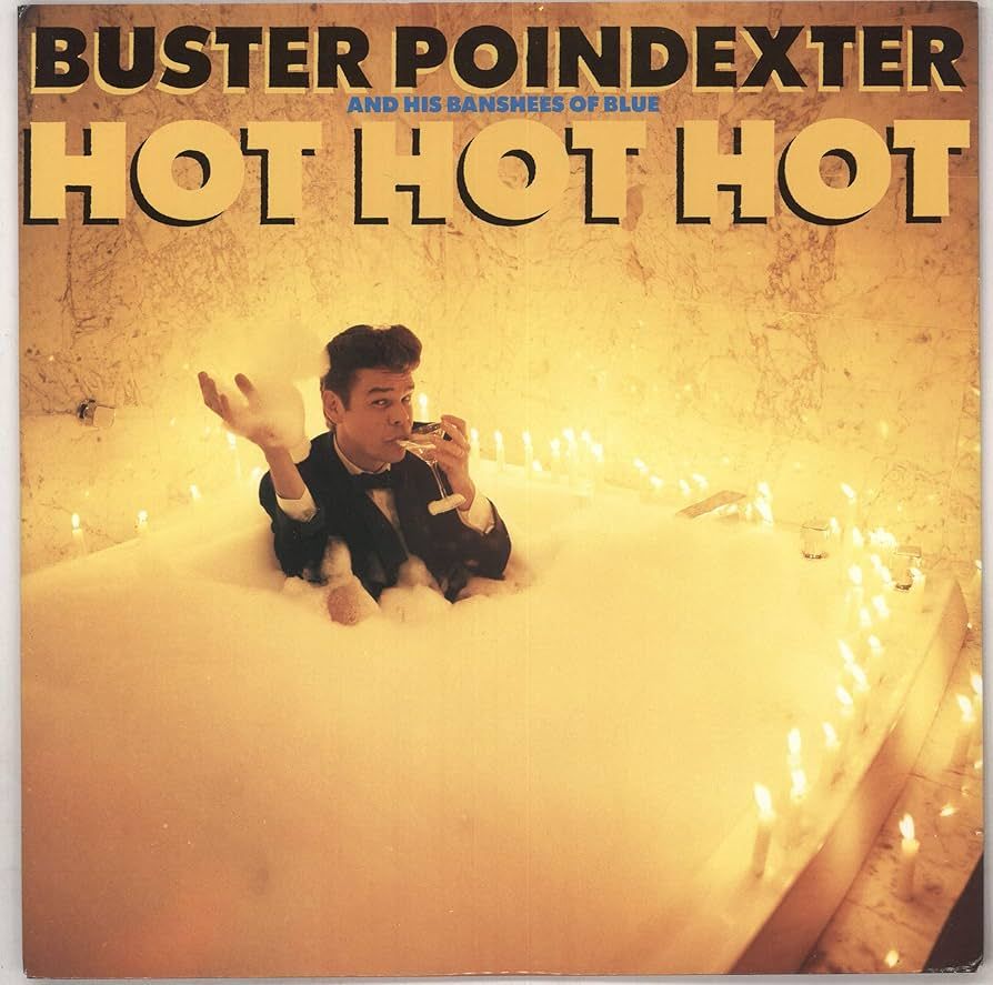 Buster Poindexter in a tub of foam, surrounded by candles, holding a glass to his lips, album cover