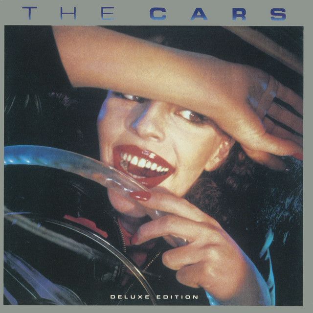 Album cover of The Cars: a woman with bright red lipstick smiles, hand over her eyes, holding a car's steering wheel.