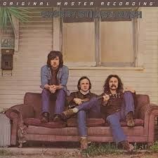 Crosby, Stills & Nash album cover: three men sit on a sofa outside a building. Brown and blue colors.