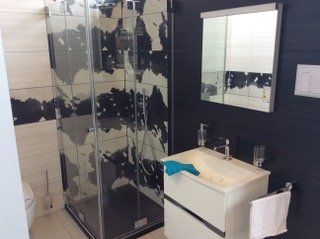 Dusche neben Waschtisch mit schwarzweißen Musterfliesen