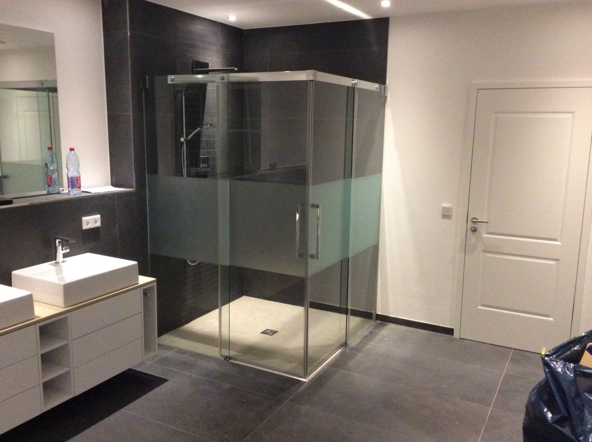 Ebenerdige Dusche in Bad mit dunklen Fliesen