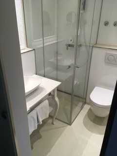 Dusche in kleinem Badezimmer neben Toilette