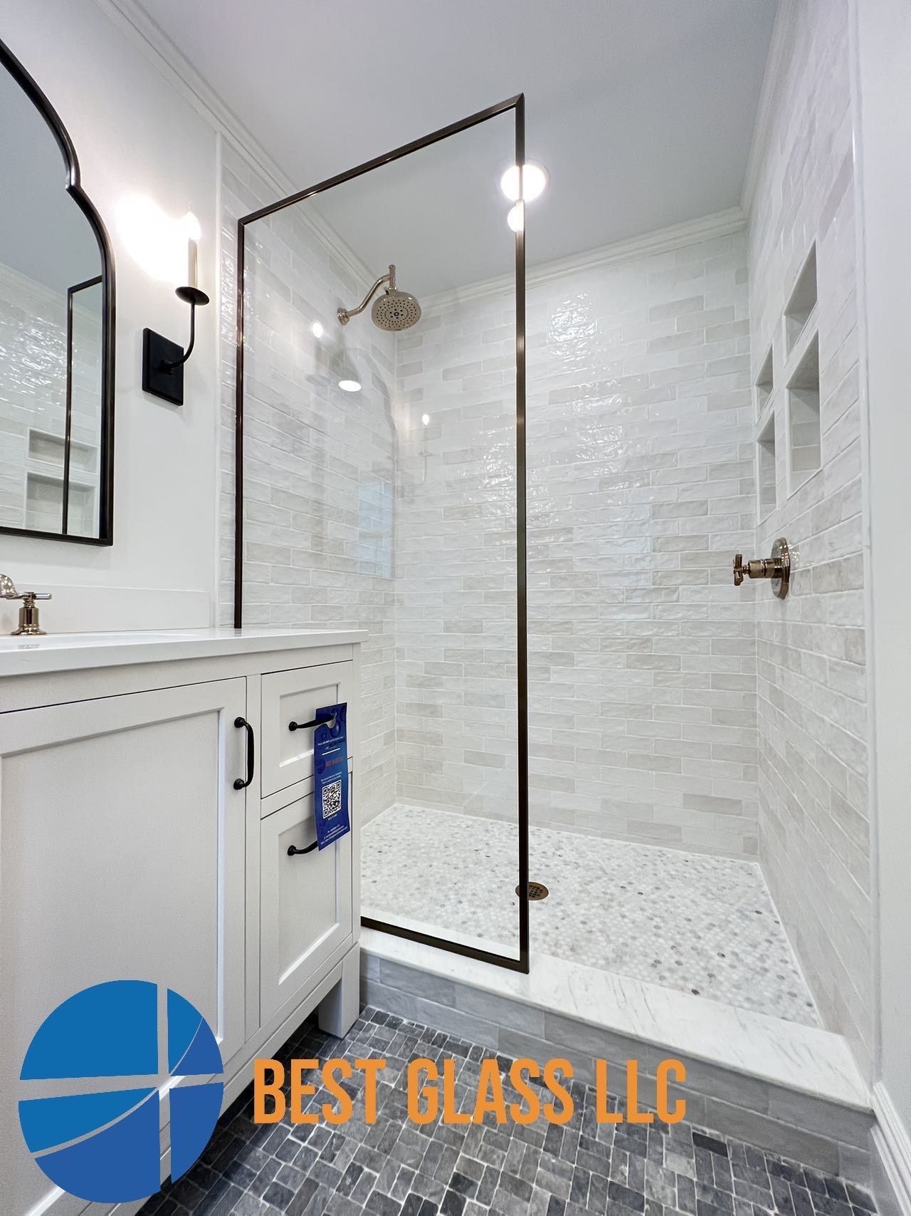 A bathroom with a walk in shower and a sink.