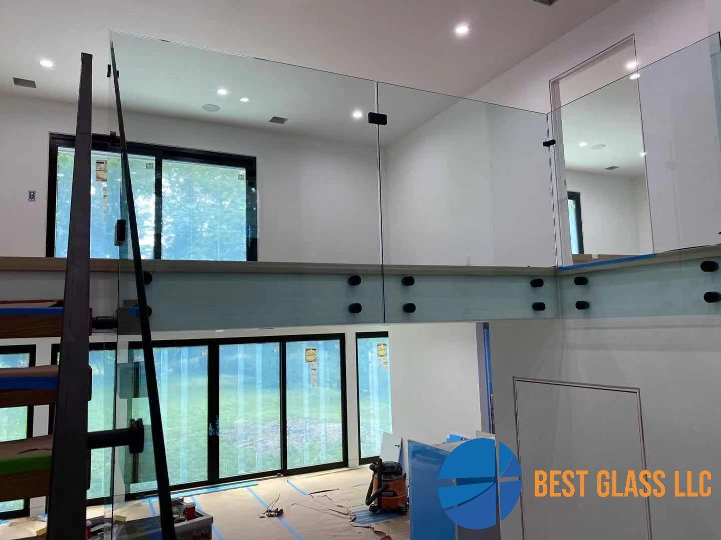A glass railing is being installed on a staircase in a house.