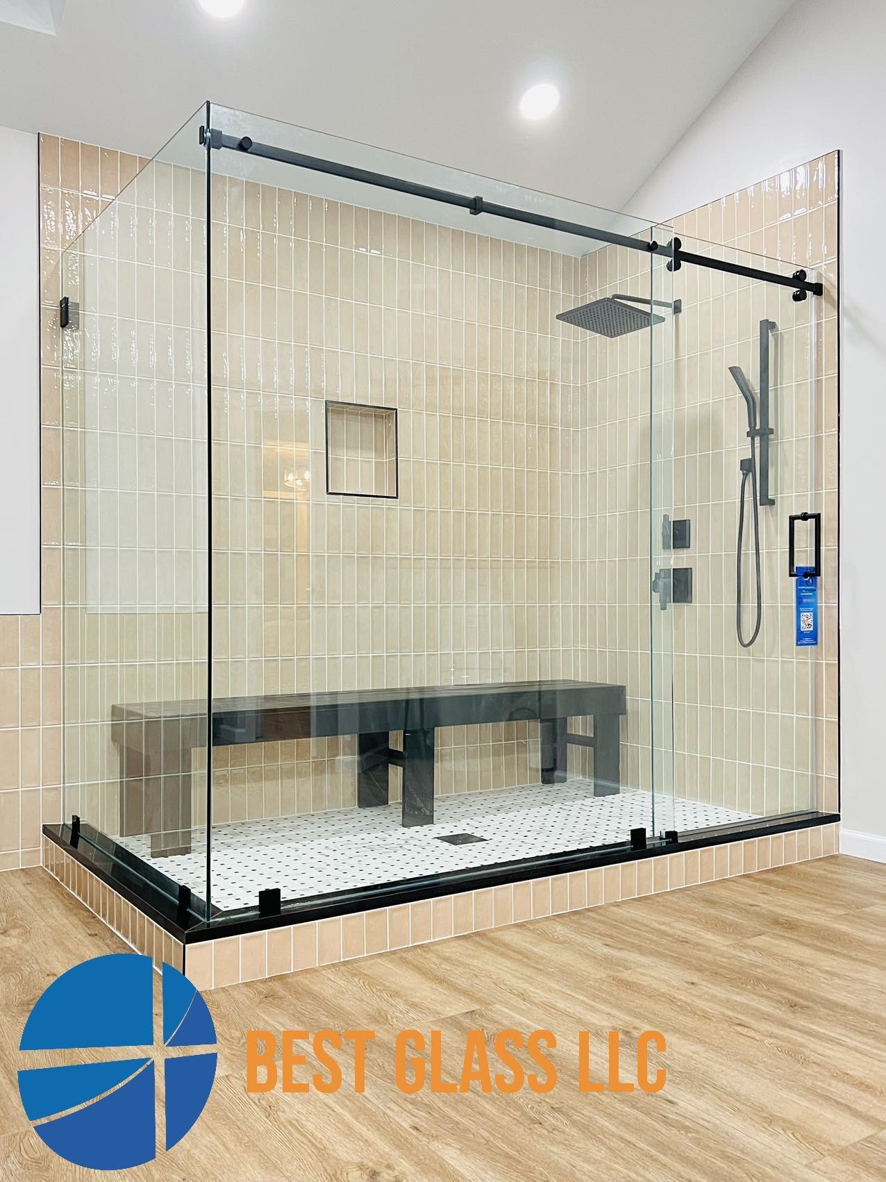 A bathroom with a sliding glass shower door and a bench.