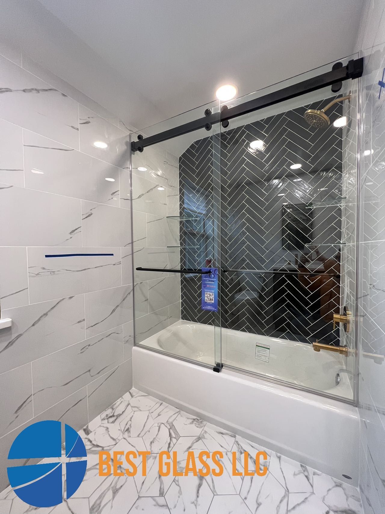 A bathroom with a bathtub and a sliding glass shower door.