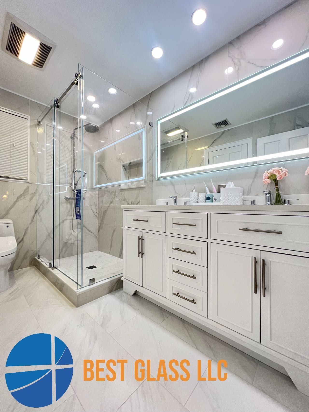 A bathroom with two sinks , a toilet , and a walk in shower.