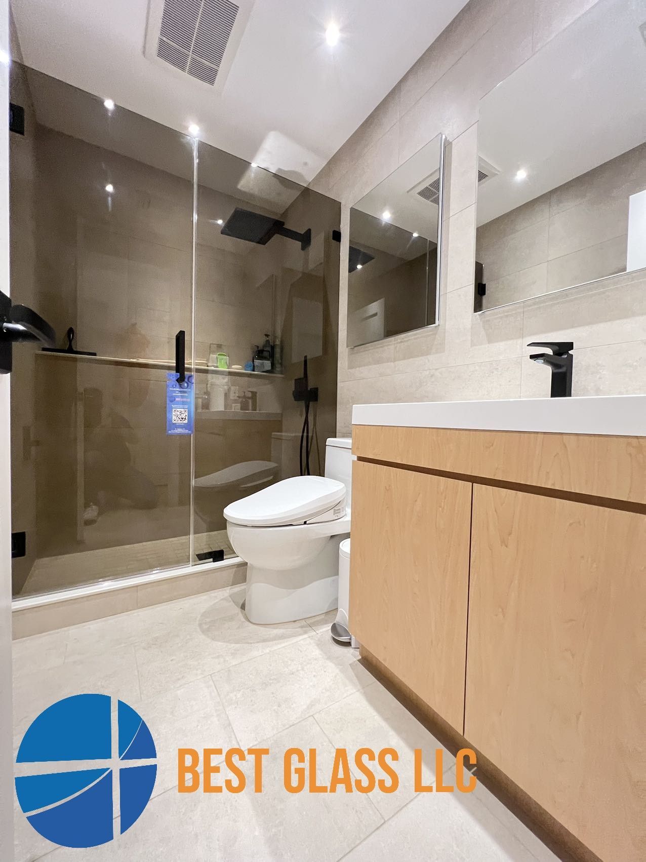 A bathroom with a toilet , sink and shower.