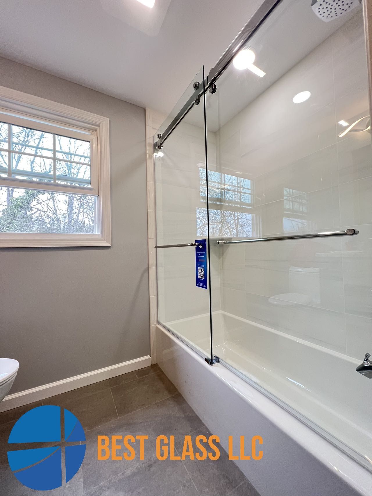 A bathroom with a sliding glass shower door and a bathtub.