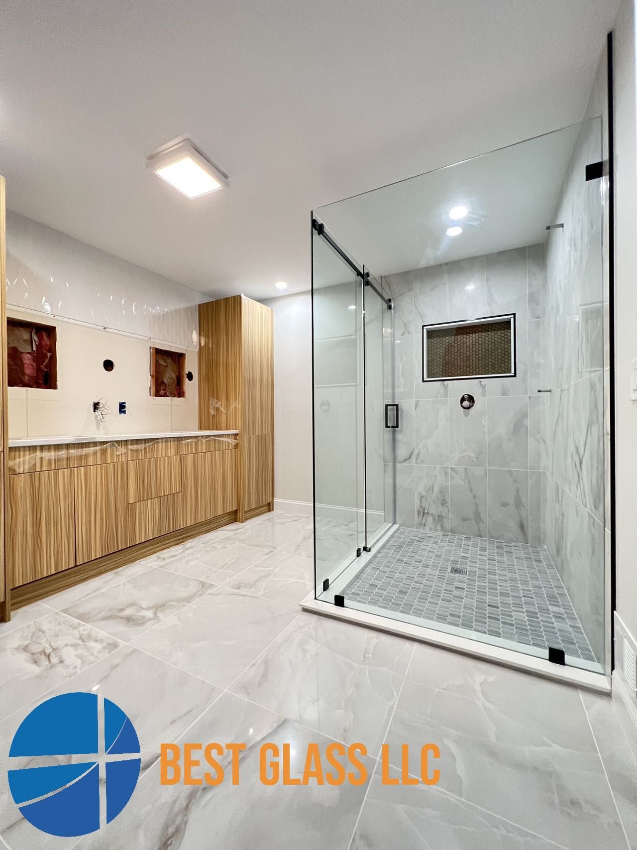 A bathroom with a walk in shower and a sink.