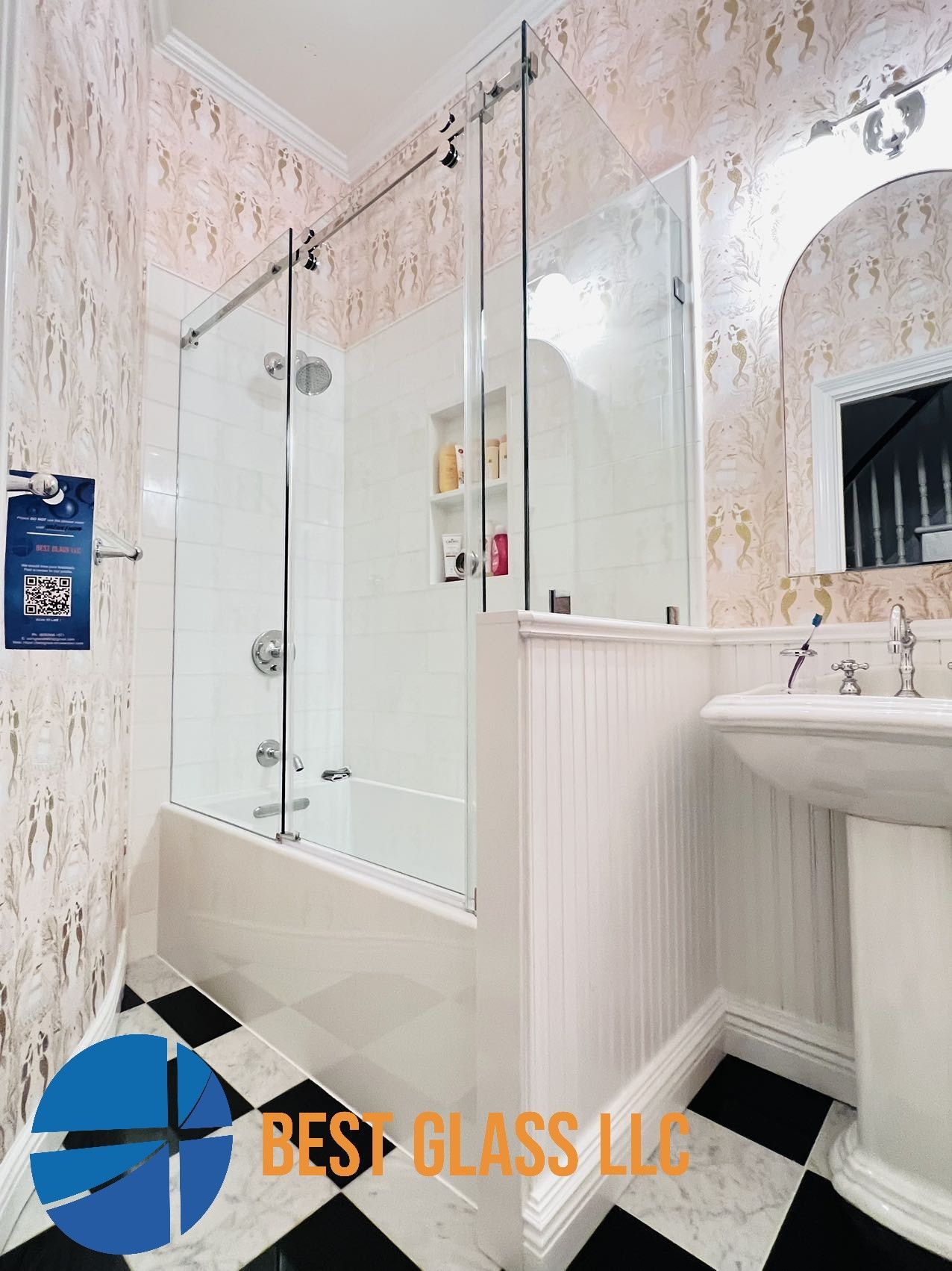 A bathroom with a sliding glass shower door and a sink