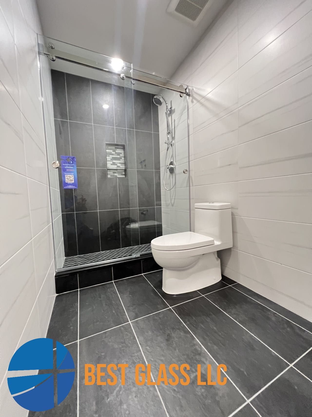 A bathroom with a toilet and a shower stall.