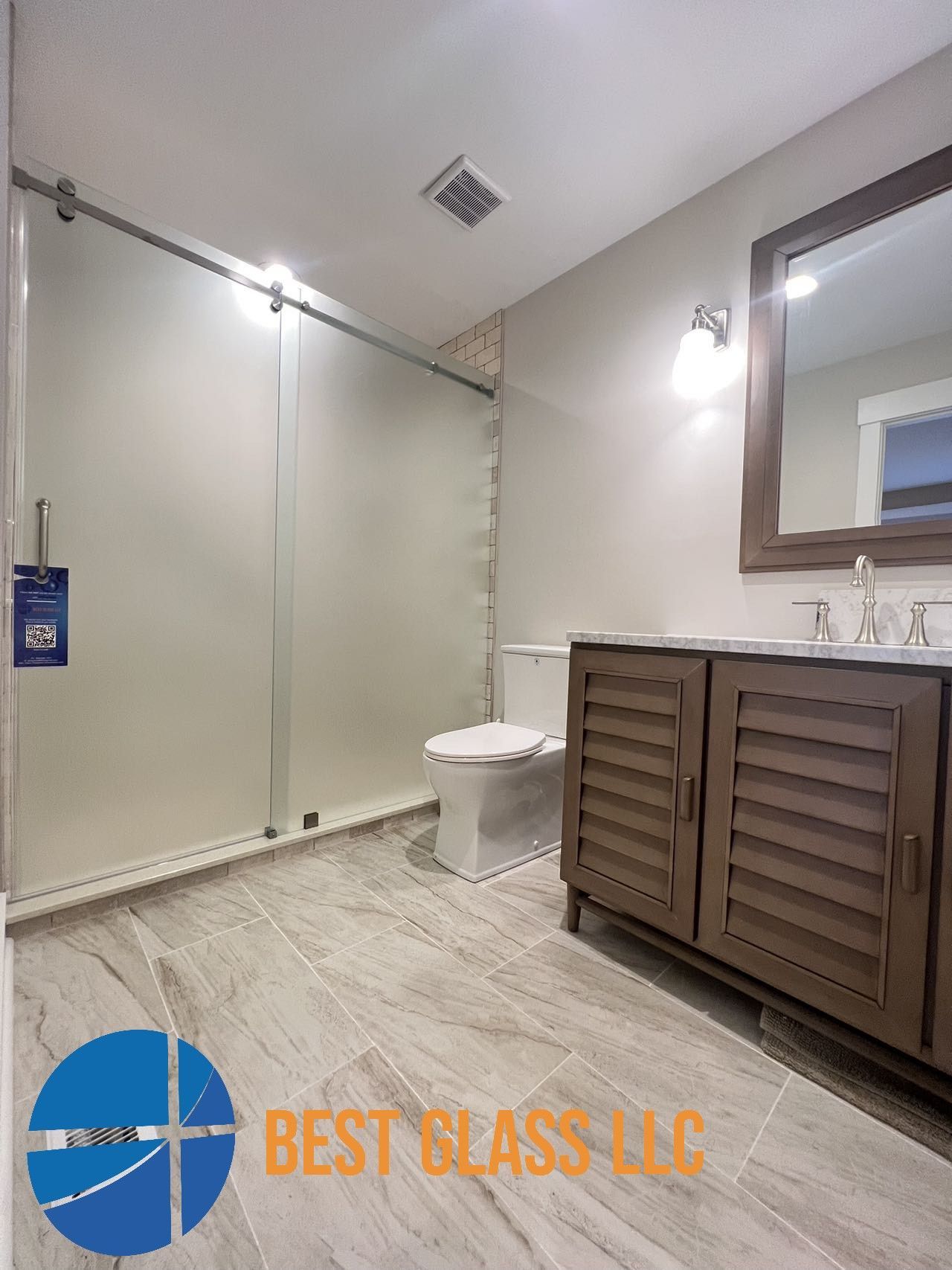 A bathroom with a toilet , sink and mirror.