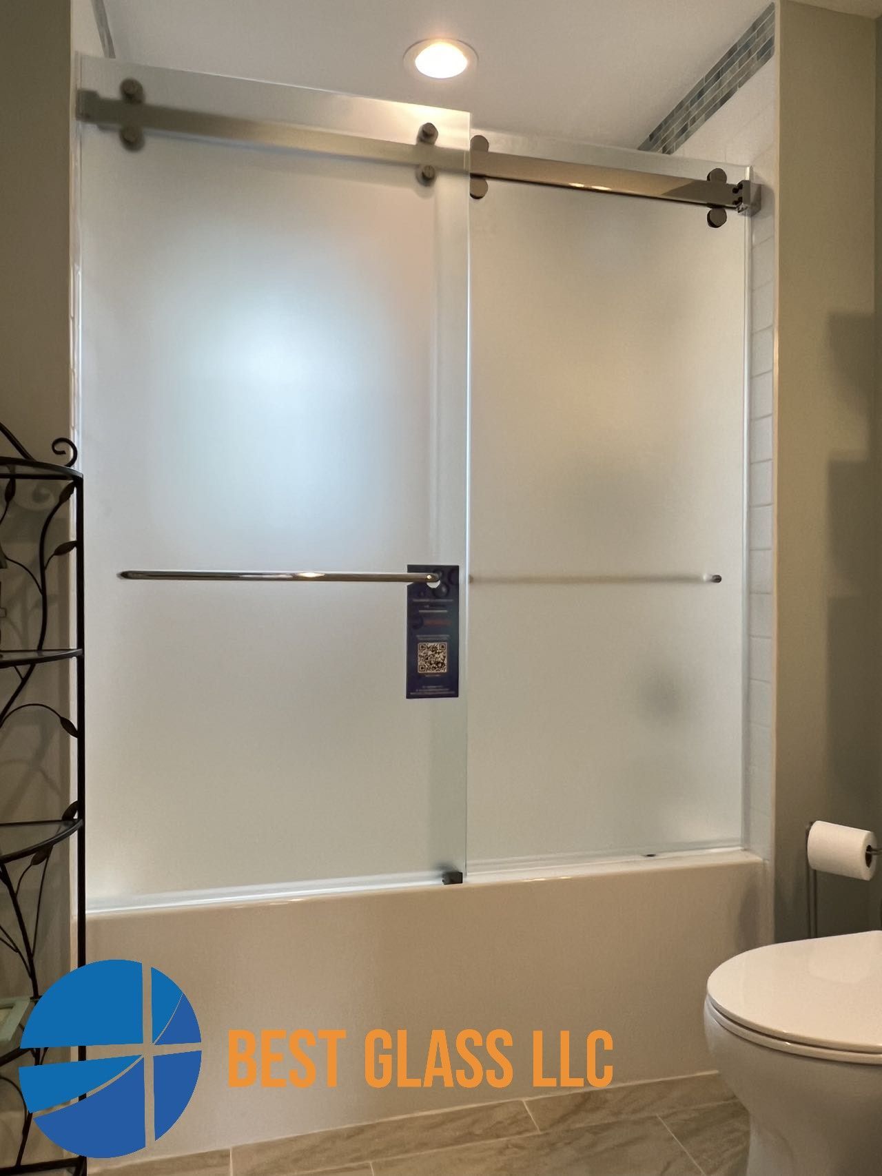 A bathroom with a sliding glass shower door and a toilet.