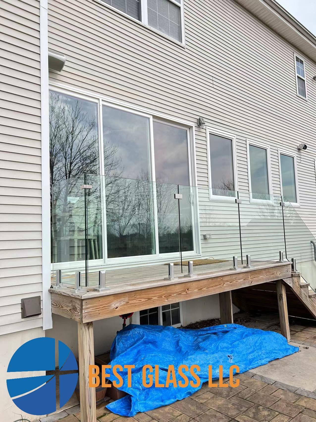 The back of a house with a glass railing on the deck.