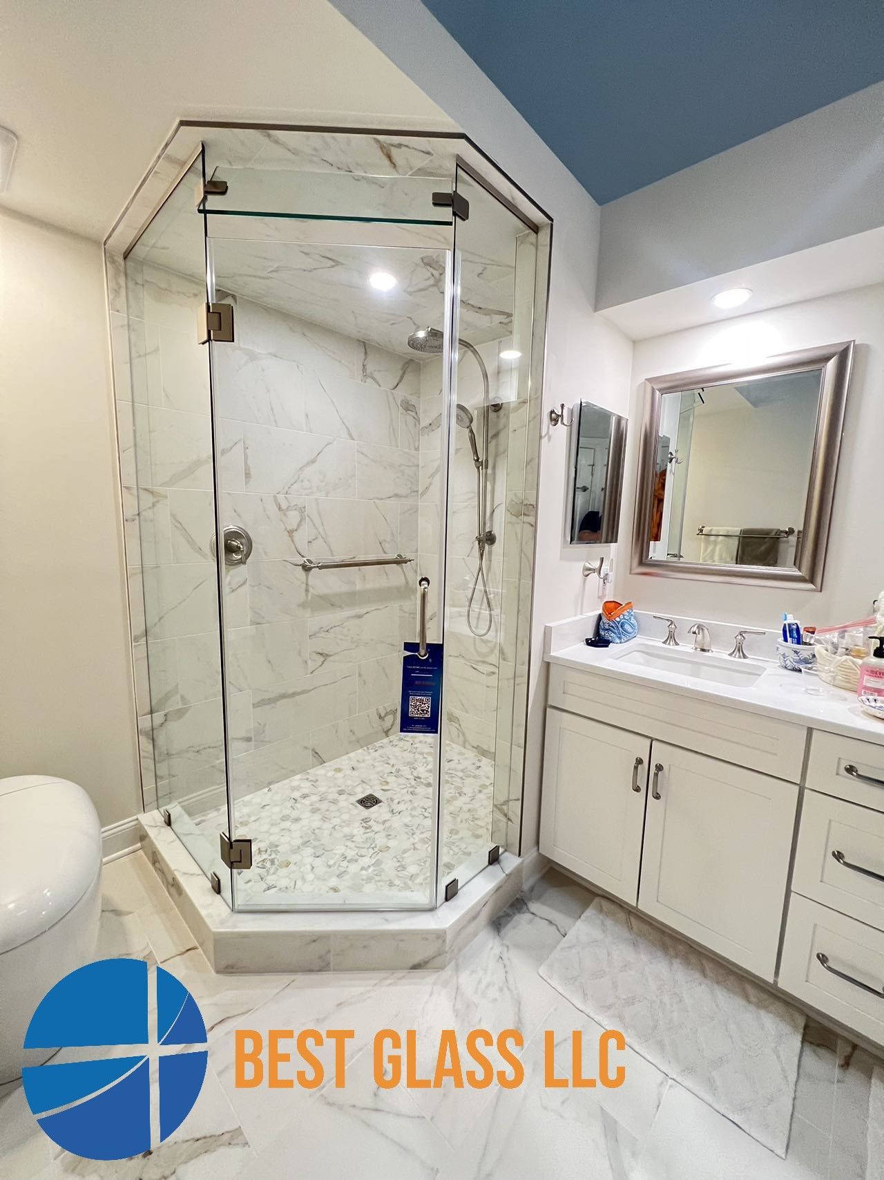 A bathroom with a walk in shower and a sink.