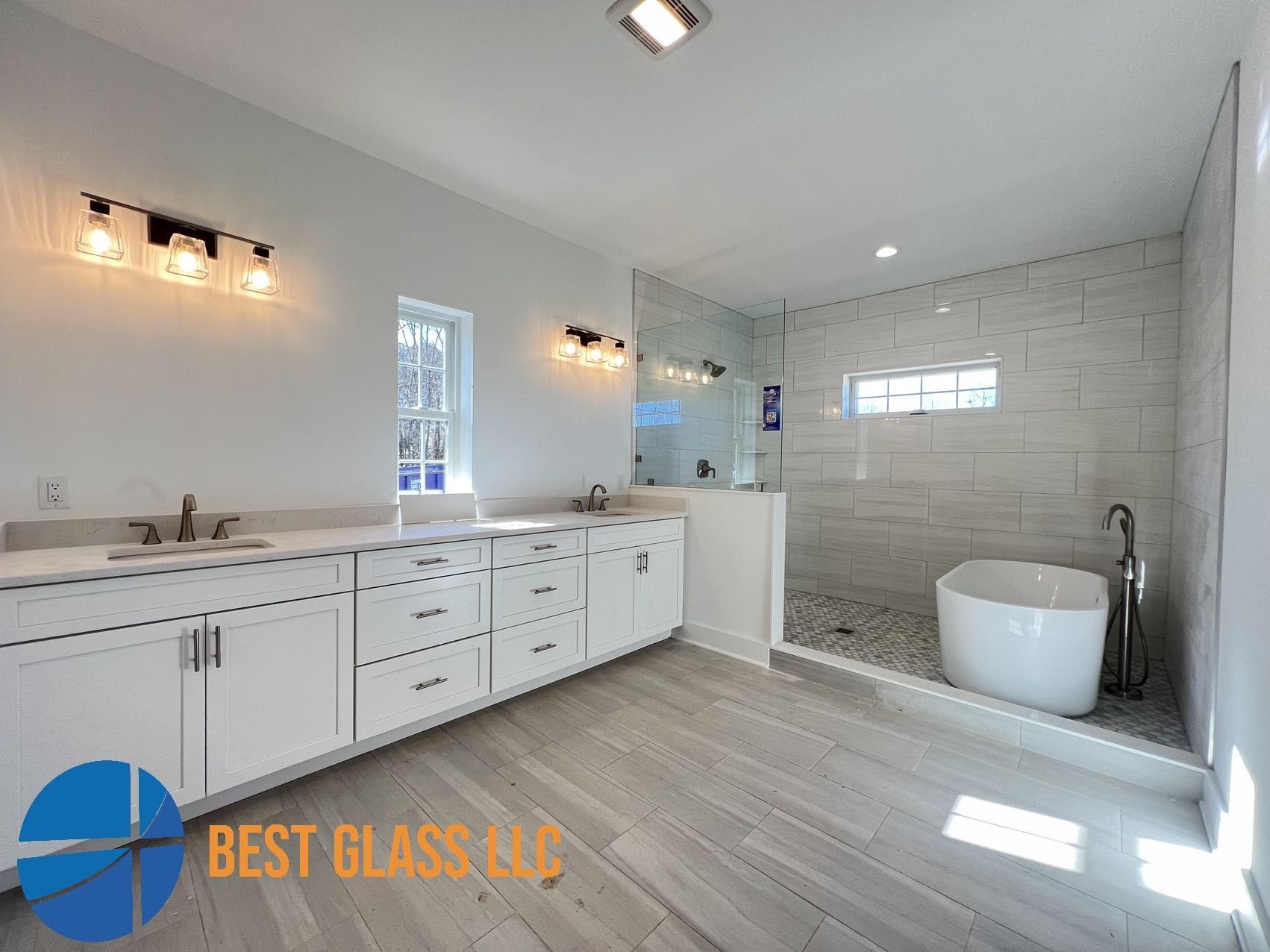 A bathroom with two sinks , a tub , and a walk in shower.