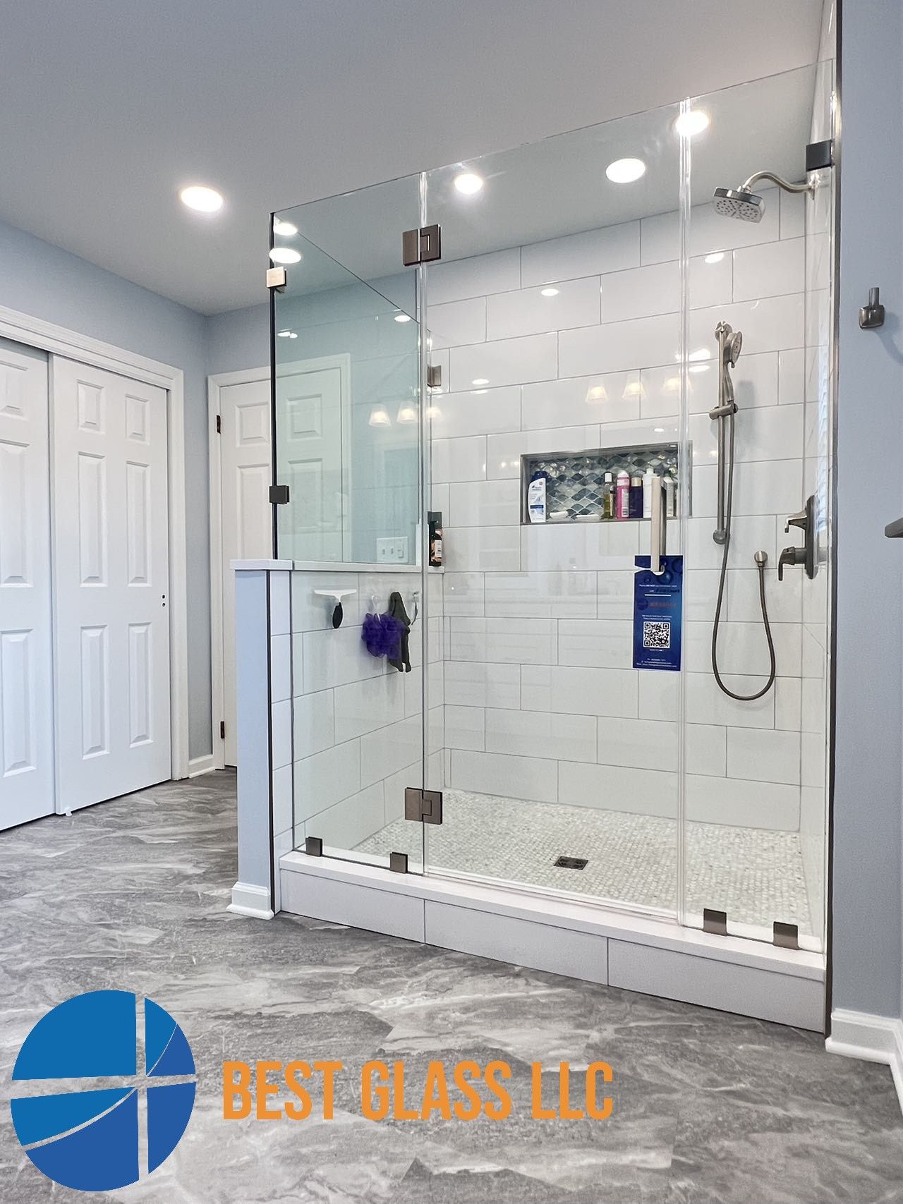 A bathroom with a walk in shower with a glass door.