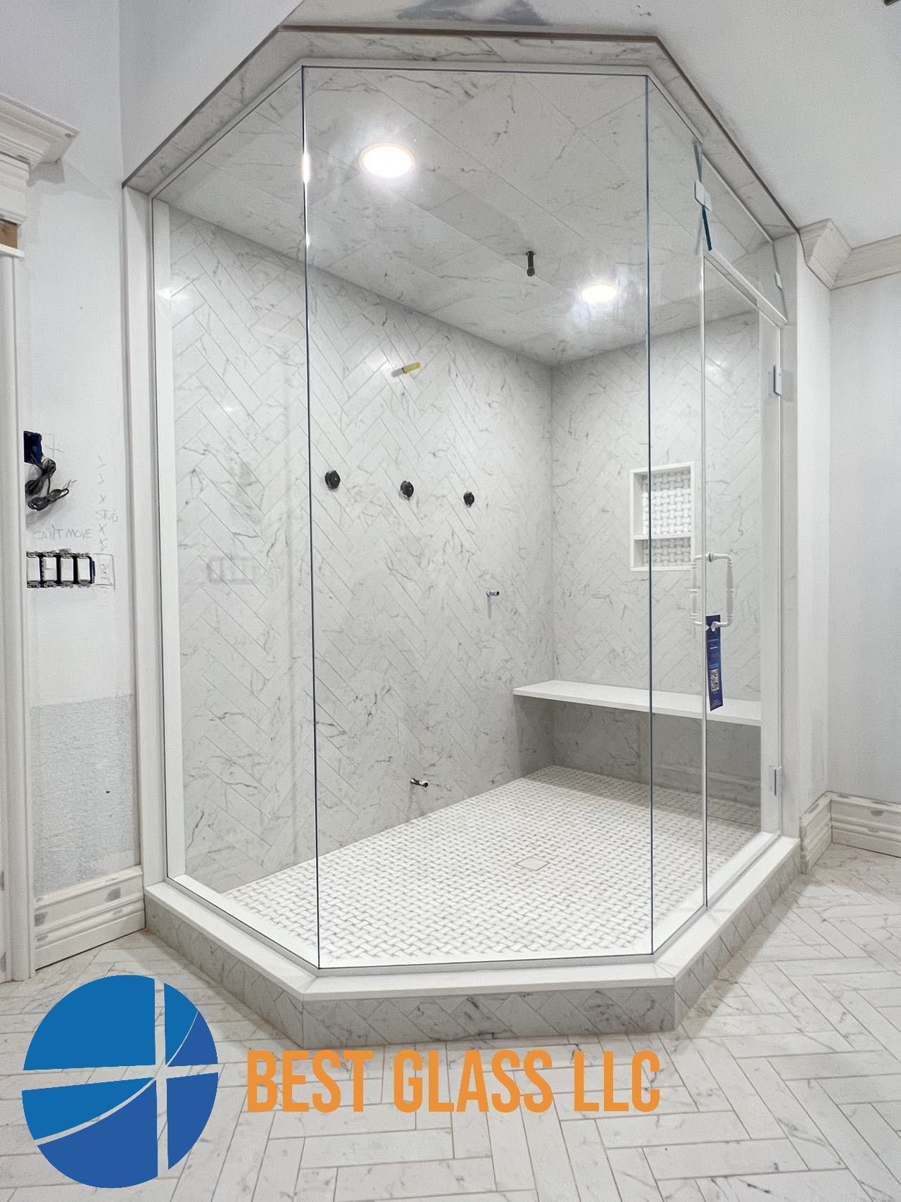 A bathroom with a shower stall and a best glass llc logo