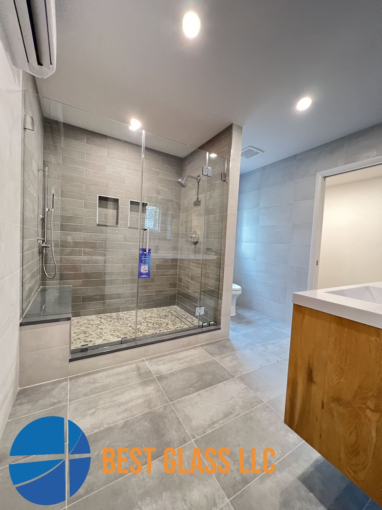 A bathroom with a walk in shower and a sink.